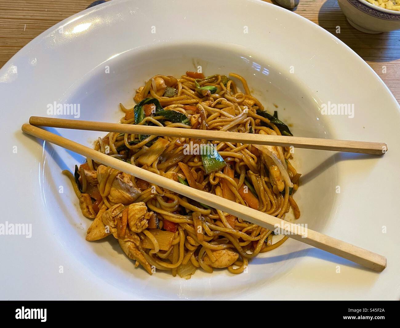 Bowl of Chicken yakisoba stir fry with chopsticks Stock Photo - Alamy