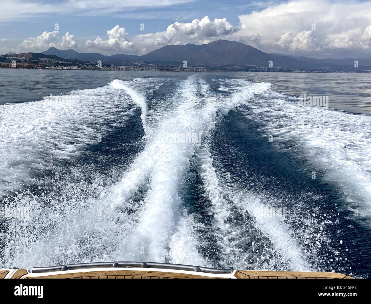 https://c8.alamy.com/comp/S45FPE/the-impressive-wake-of-a-fast-speed-boat-with-the-coastline-of-spain-in-the-distance-S45FPE.jpg
