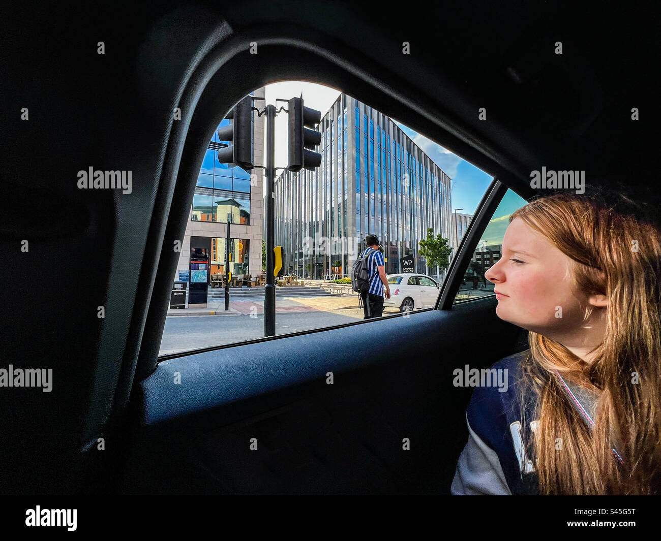 Young women looking out of car window in city centre - Smartphone Captured Stock Image