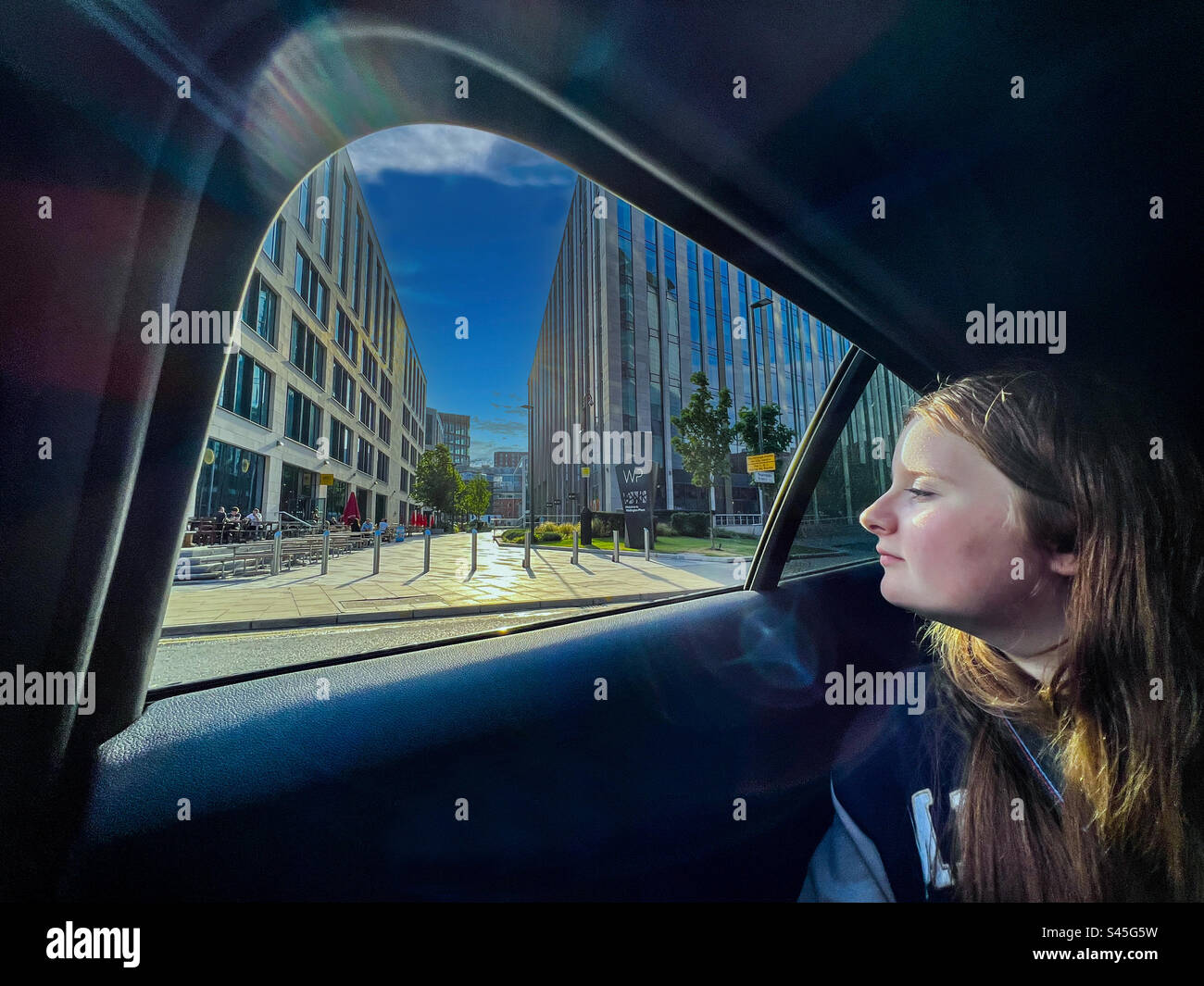 Young women looking out of car window in city centre - Smartphone Captured Stock Image
