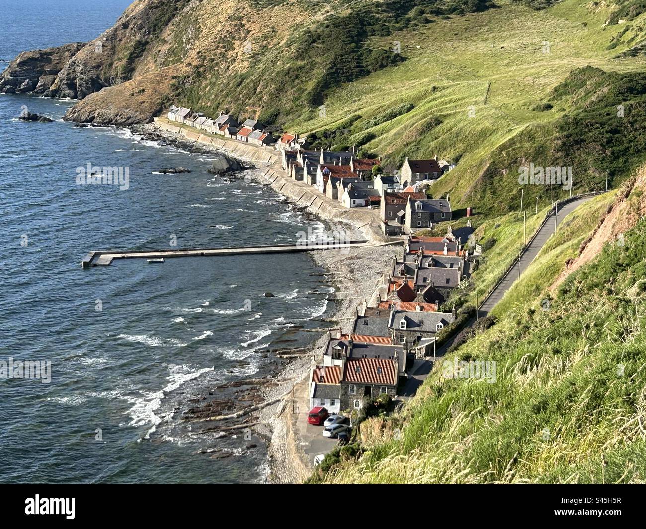 Aerial view of seaside village of Crovie in Scotland. The cottages are very close to the sea with no cars able to drive in front - Smartphone Captured Stock Image