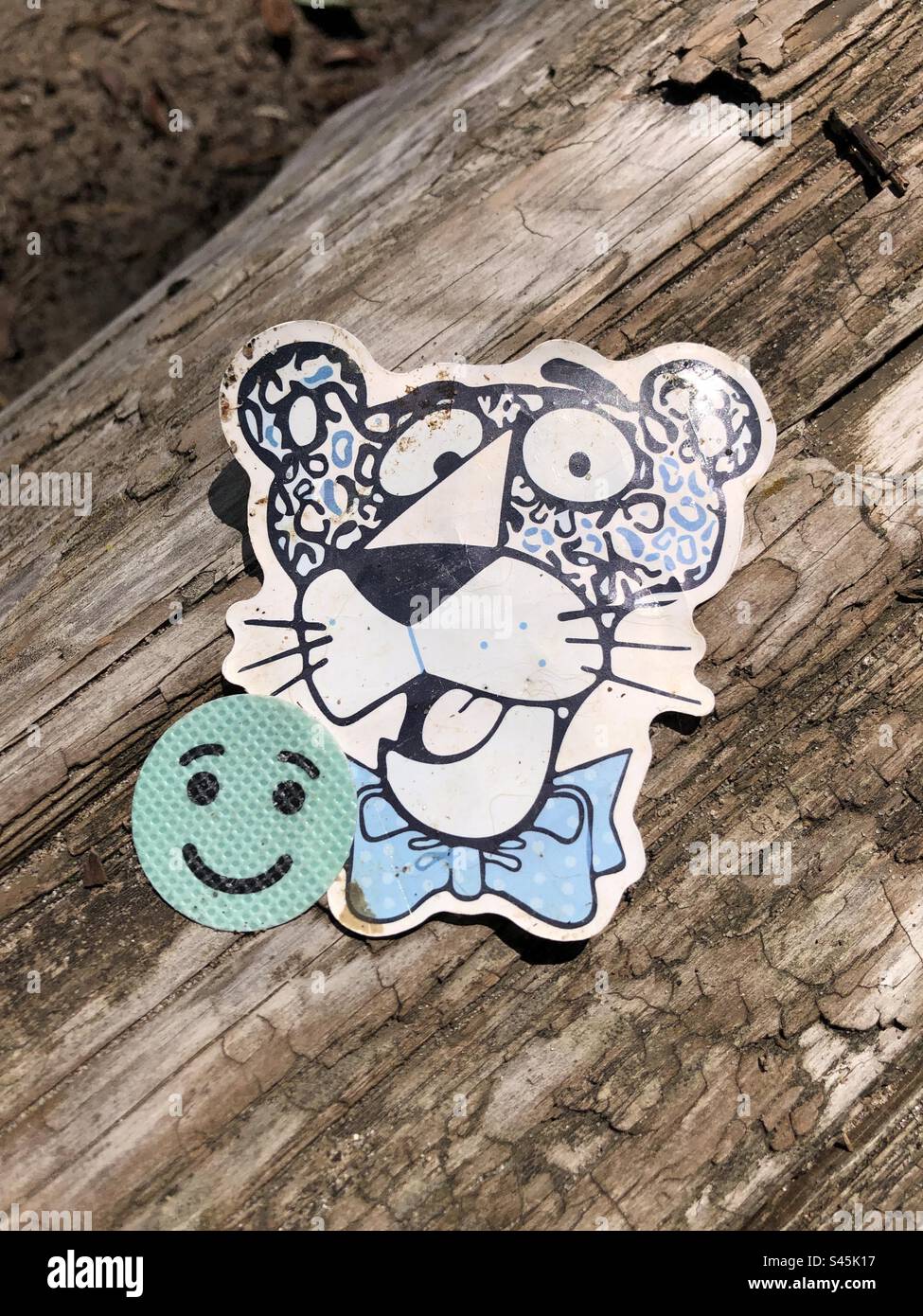 Cute whimsical stickers on a log. - Smartphone Captured Stock Image