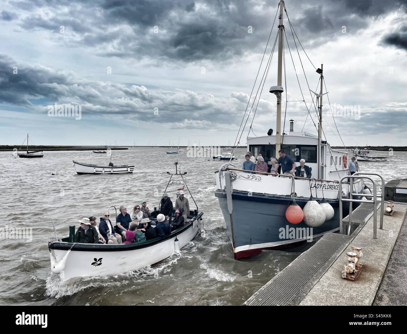 Orford Suffolk with the Orfordness ferry and Lady Florence restaurant motor cruiser arriving at the quay - Smartphone Captured Stock Image