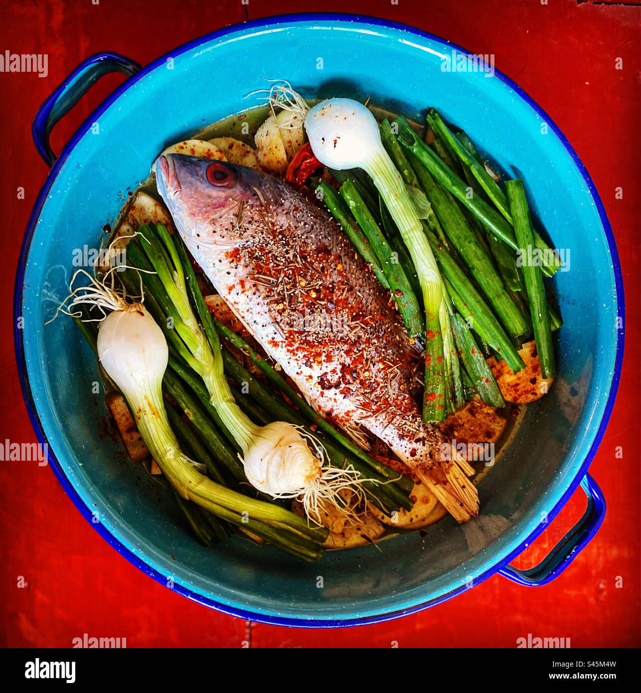 A red snapper with potatoes and onions ready to be cooked in Queretaro, Mexico - Smartphone Captured Stock Image