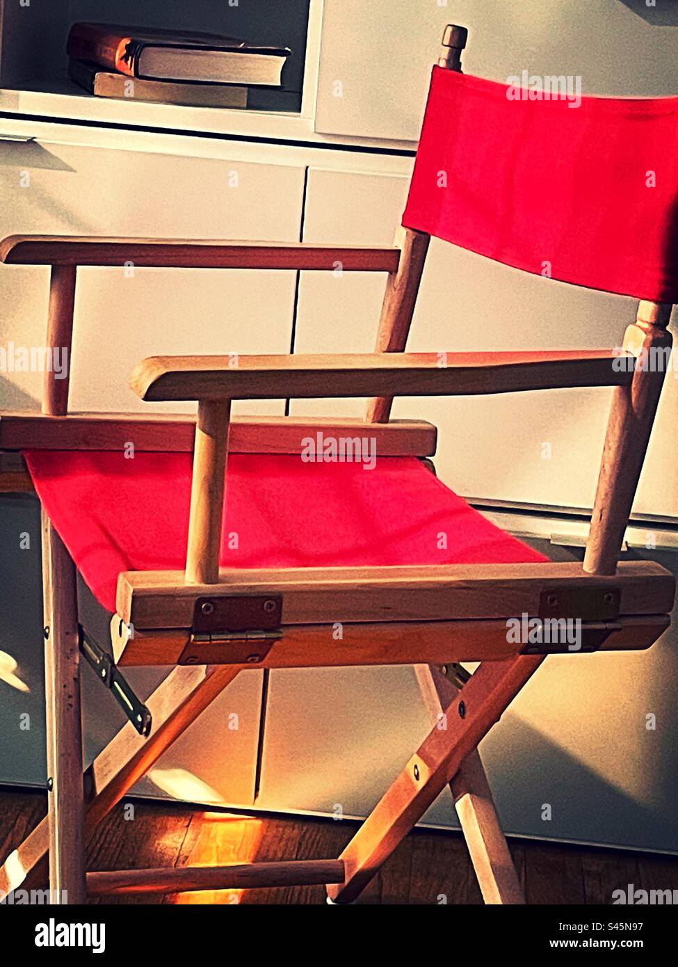 Directors chair with red cloth panels, and a wooden frame, 2023, residential apartment, New York City, USA - Smartphone Captured Stock Image