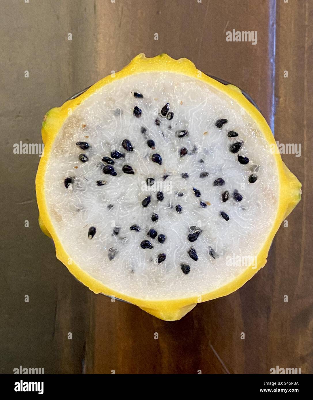 A yellow dragon fruit sliced open showing the seeds. Also called Pitahaya. - Smartphone Captured Stock Image