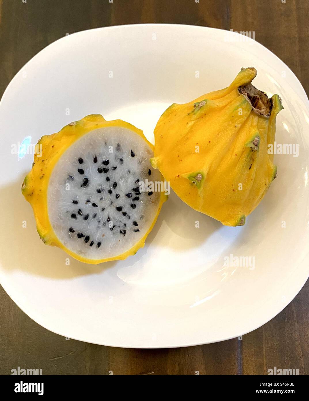 Cut yellow dragon fruit – Pitahaya – on a plate. Stock Photo