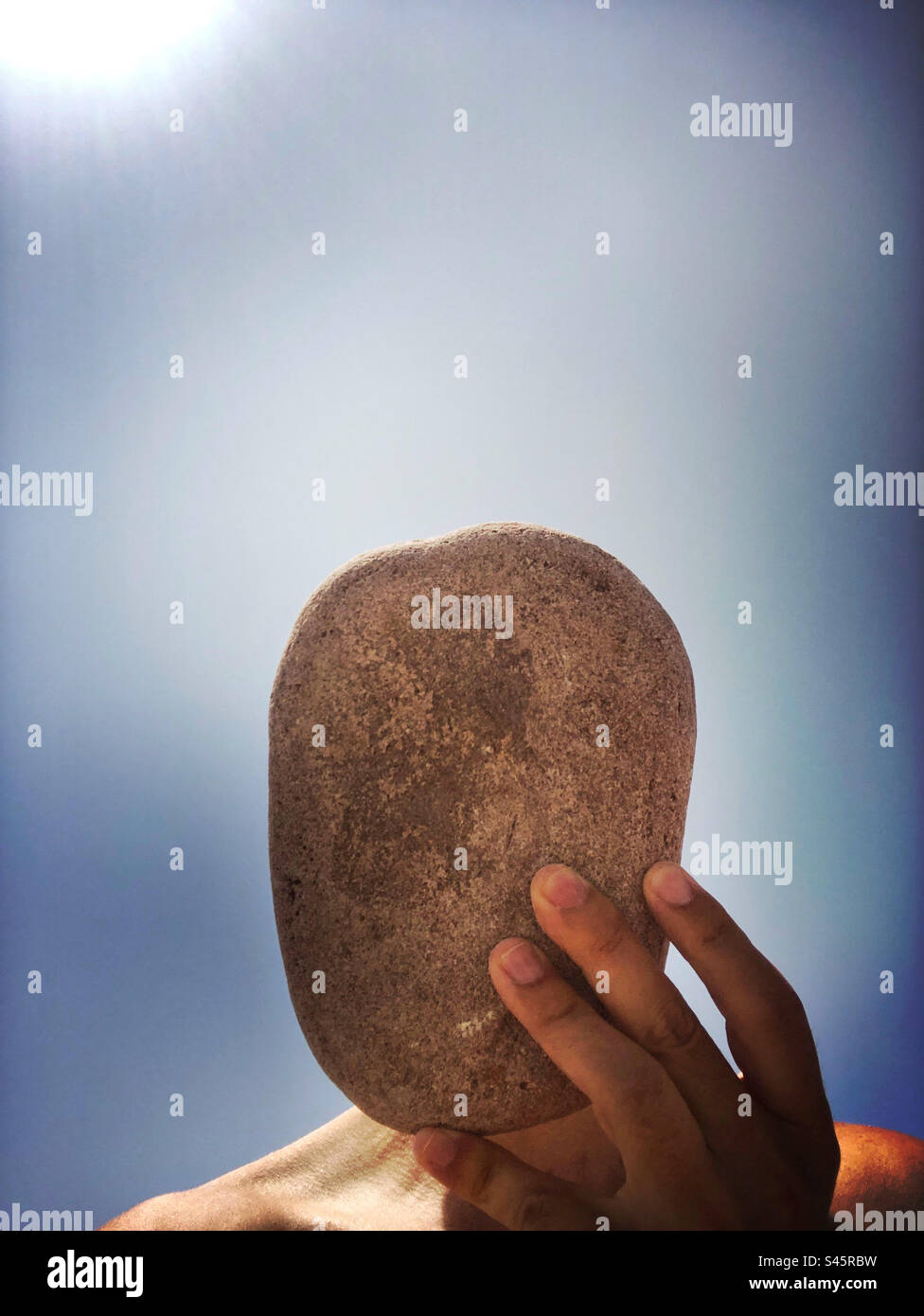 Person holding a big stone before their face - Smartphone Captured Stock Image