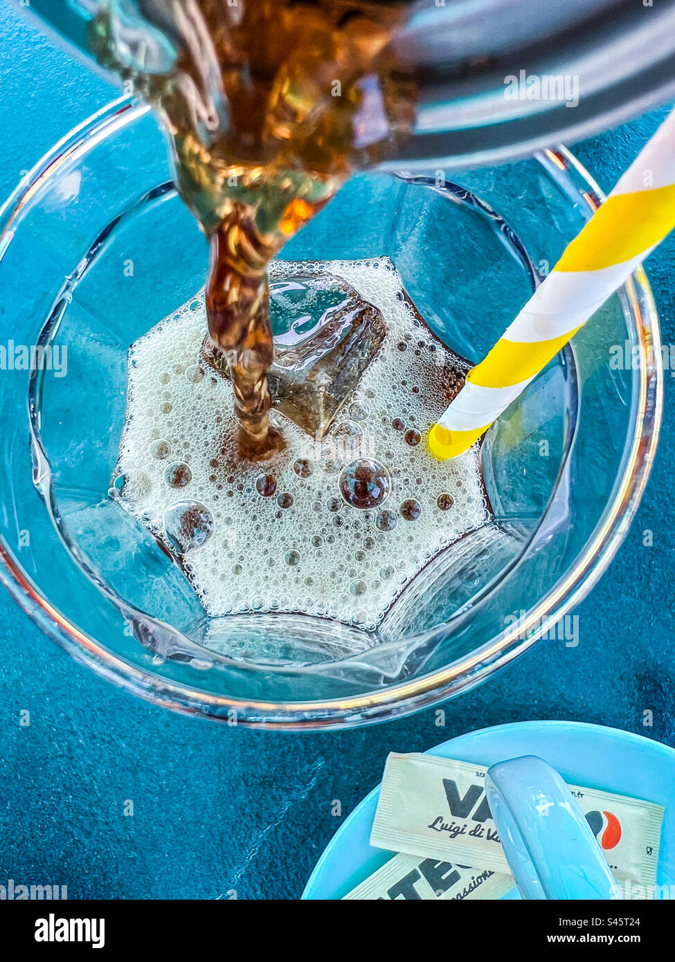 Pouring cola into glass with ice cubes - Smartphone Captured Stock Image