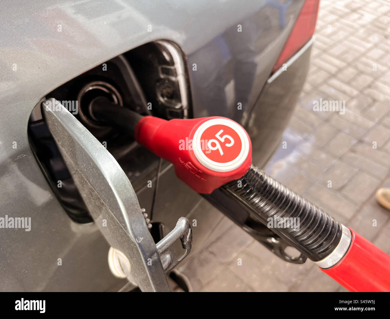 fuel nozzle filling petrol into car tank at gas station Stock Photo Alamy
