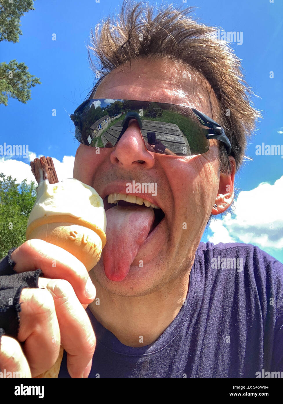 Middle aged cyclist selfie licking an ice cream - Smartphone Captured Stock Image Middle aged cyclist selfie licking an ice cream - Smartphone Captured Stock Image