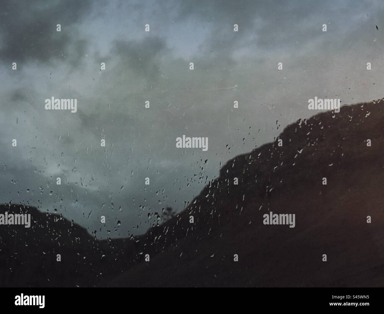 A dark minimal mountain and sky landscape with raindrops Stock Photo