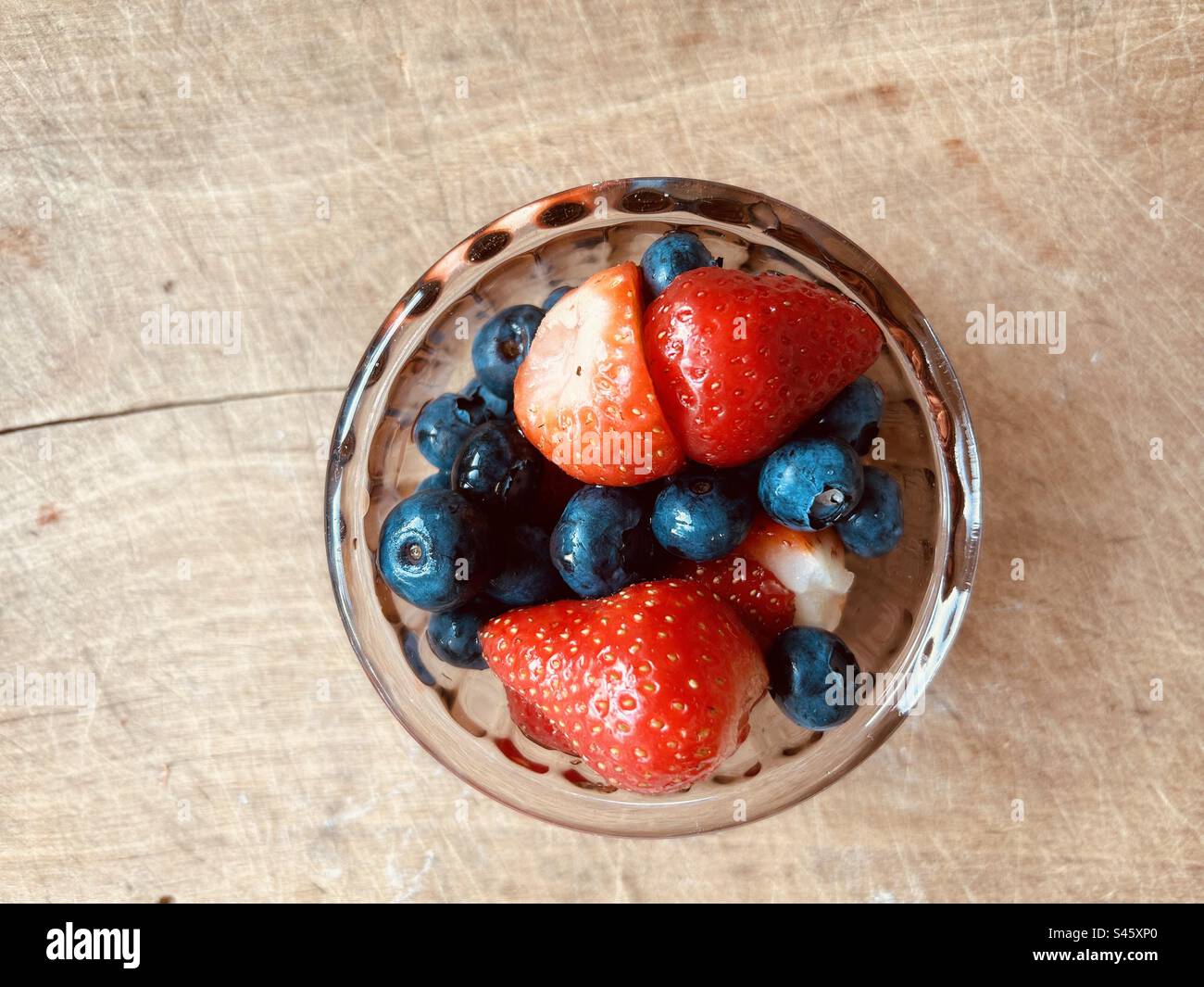Colourful summer blueberries  and strawberries in a small glass bowl. - Smartphone Captured Stock Image