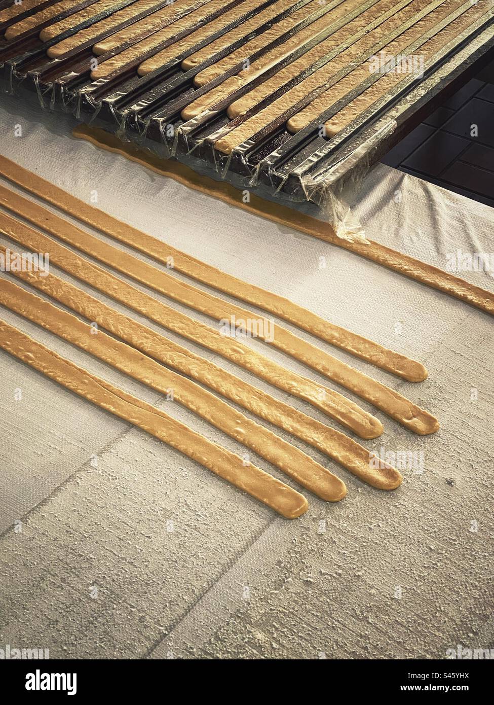 Coconut candy factory. Traditional Vietnamese coconut candy strips before cutting and packing. - Smartphone Captured Stock Image