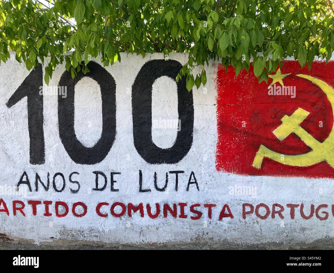 Wall in the south of Portugal with mural painting commemorating the one hundred of existence of communist Portuguese party. Stock Photo