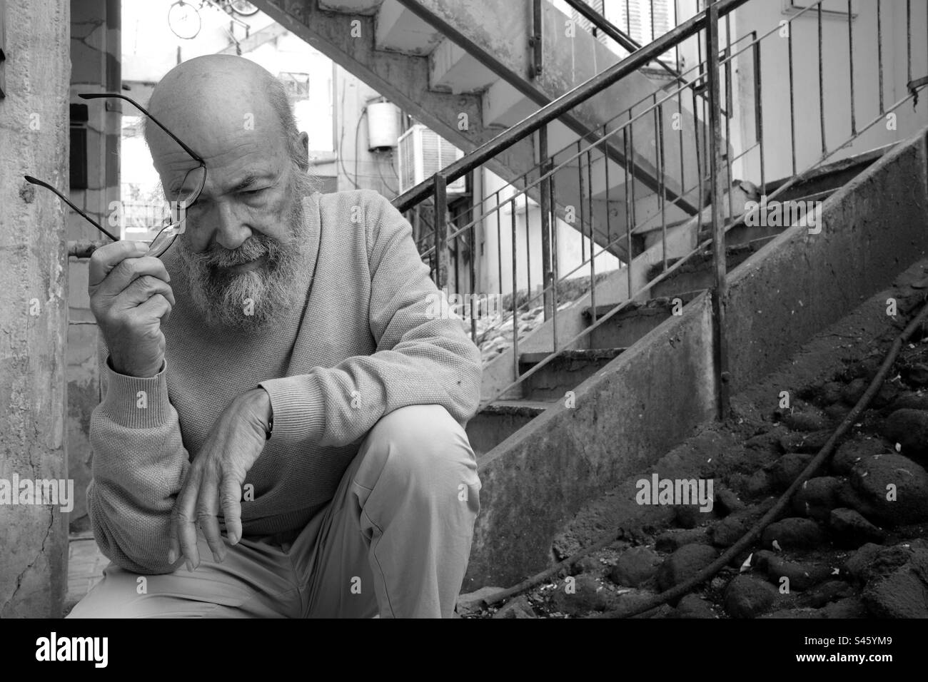 Sad old man in town BW Stock Photo