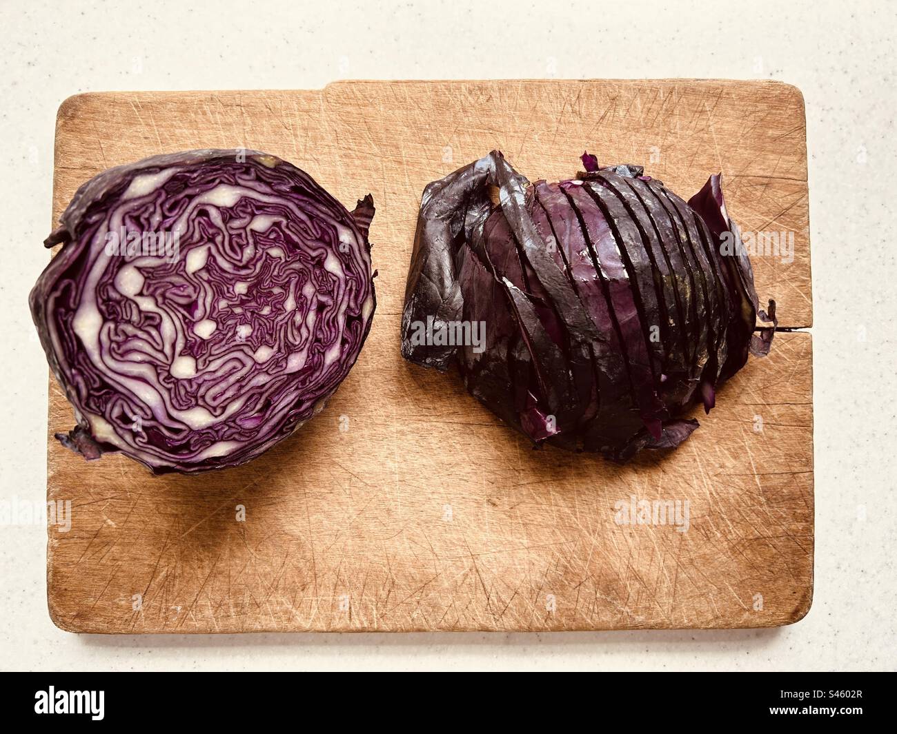 Partially sliced red cabbage on old wooden chopping board. Ready to cook or add to a salad. - Smartphone Captured Stock Image