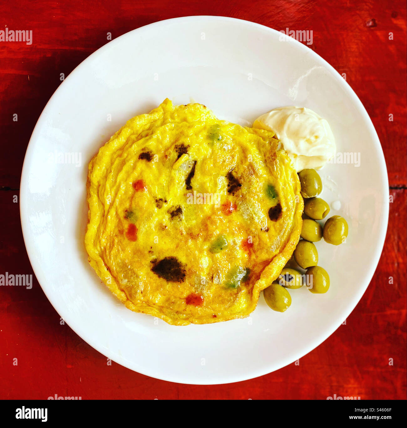 Spanish potato tortilla with olives and habanero chilli sauces in Queretaro, México - Smartphone Captured Stock Image