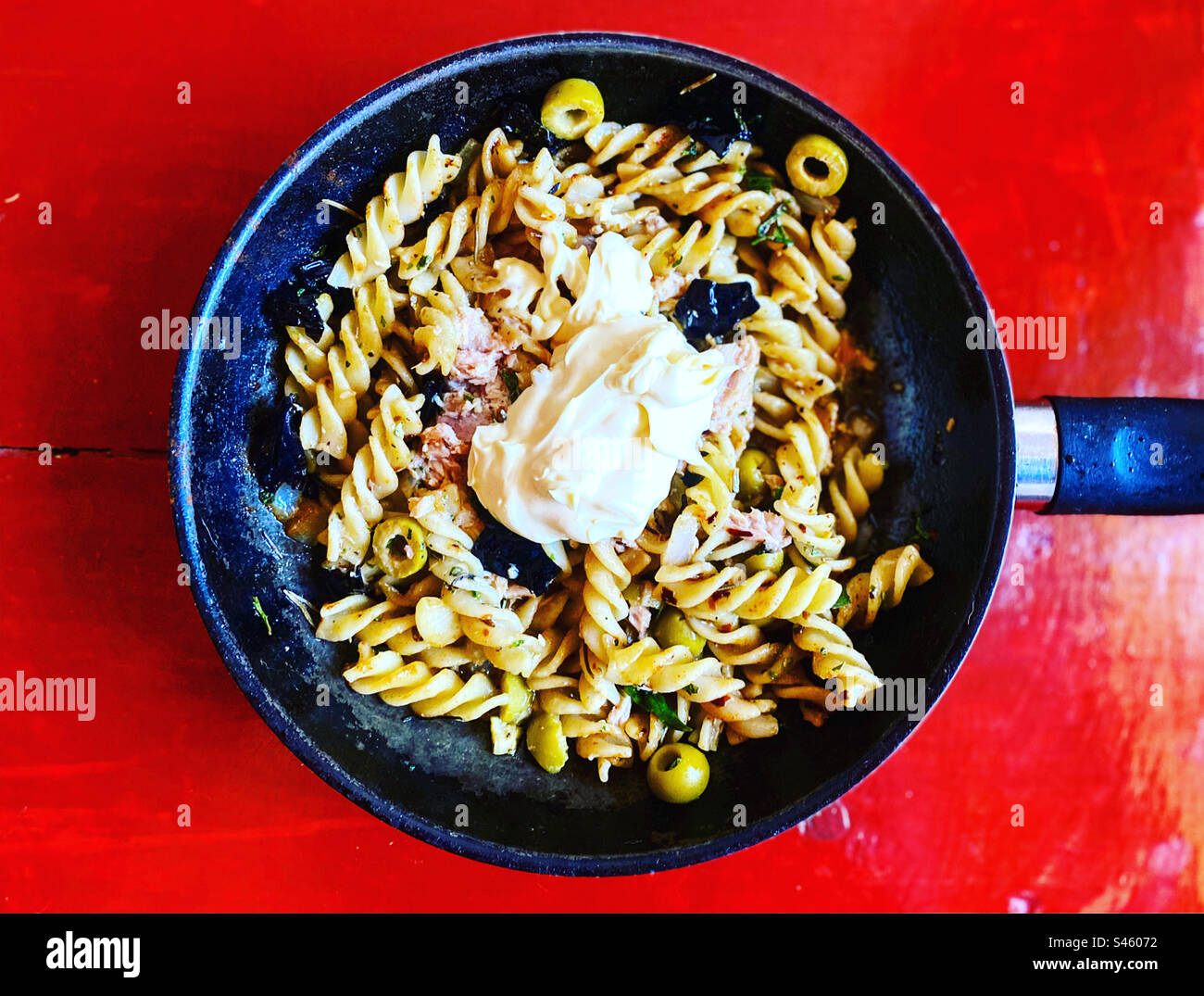 Pasta with fine herbs, chilli peppers, olives and mayonnaise in a pot in Querétaro, México - Smartphone Captured Stock Image