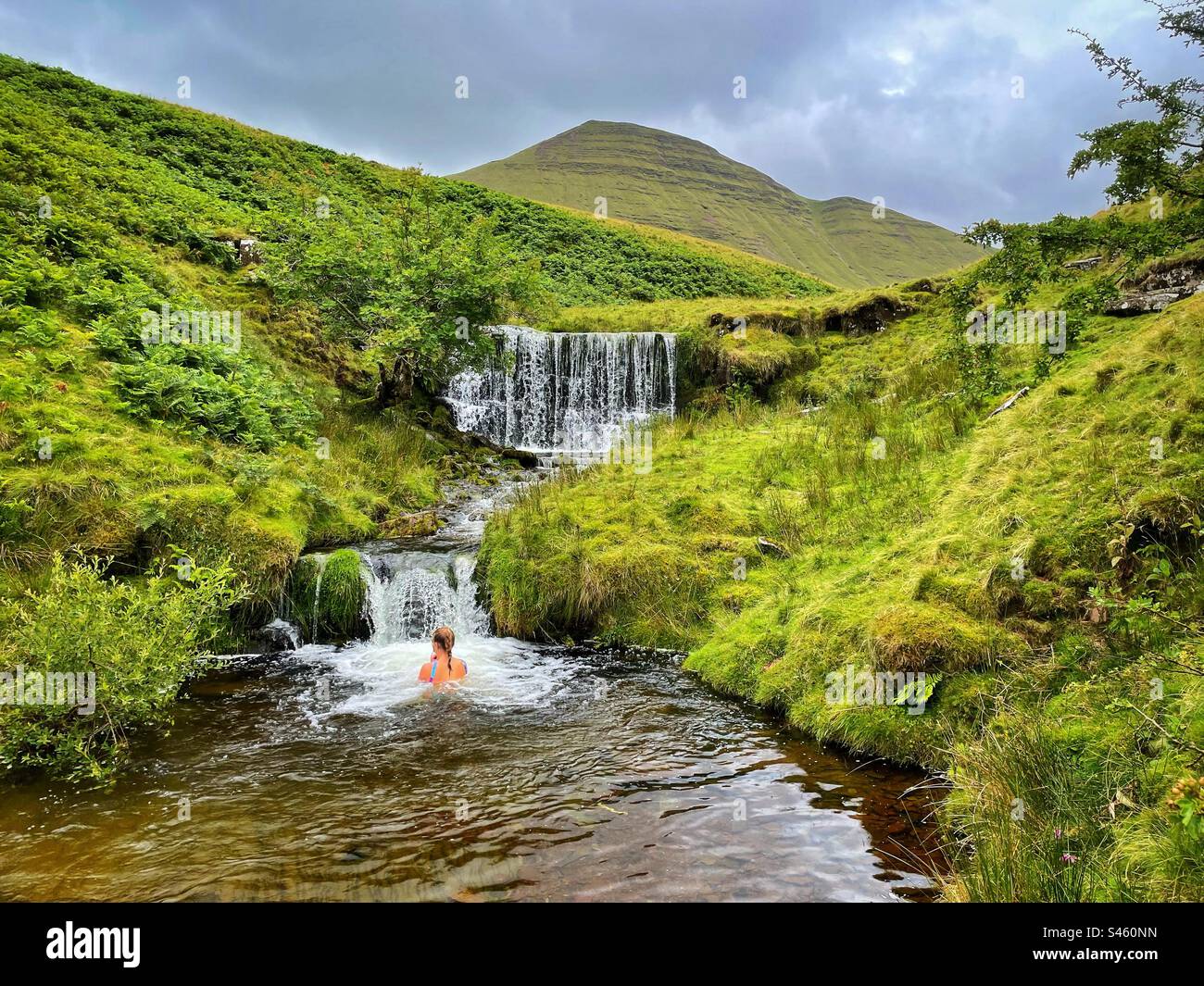 Young Woman wild swimming in a waterfall below Cribyn in Bannau Brycheniog ( Brecon Beacons), July. - Smartphone Captured Stock Image
