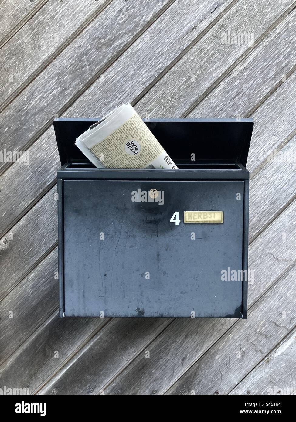 Letterbox with number 4 and newspaper inside. Germany Stock Photo
