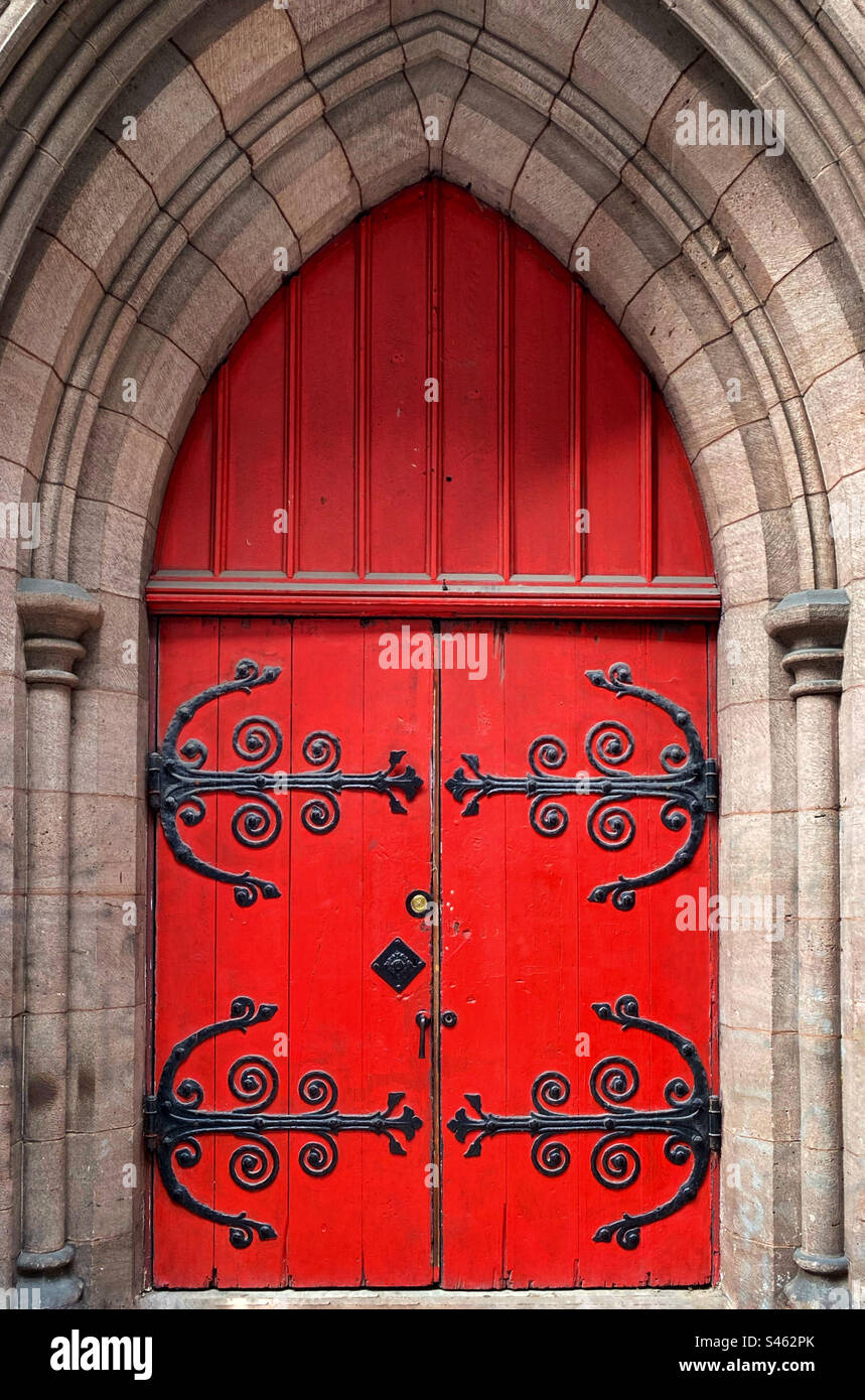 Red church door with elaborate iron hinges - Smartphone Captured Stock Image