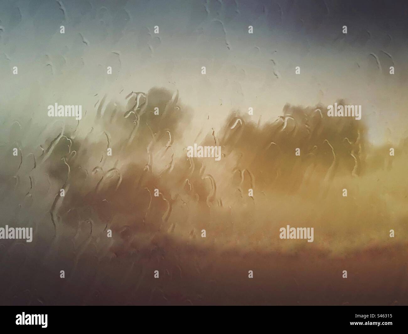 Clouds and sky background with rain and raindrops on a glass window- wet weather sky cloud backdrop - Smartphone Captured Stock Image