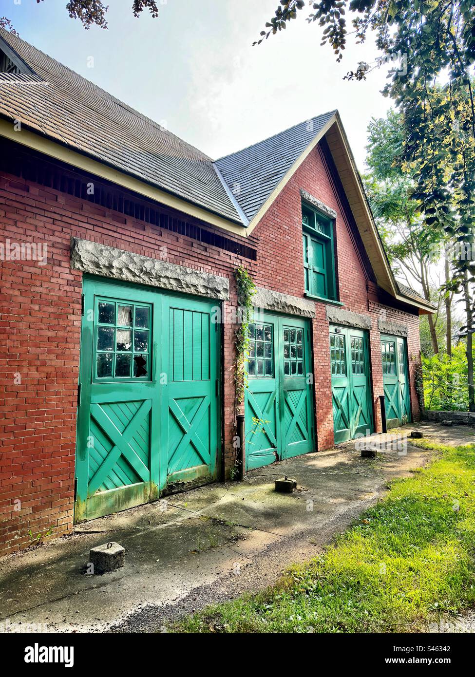Old, red brick barn at Harkness Memorial State Park in Waterford, Connecticut, USA. Falling apart and in disrepair. - Smartphone Captured Stock Image