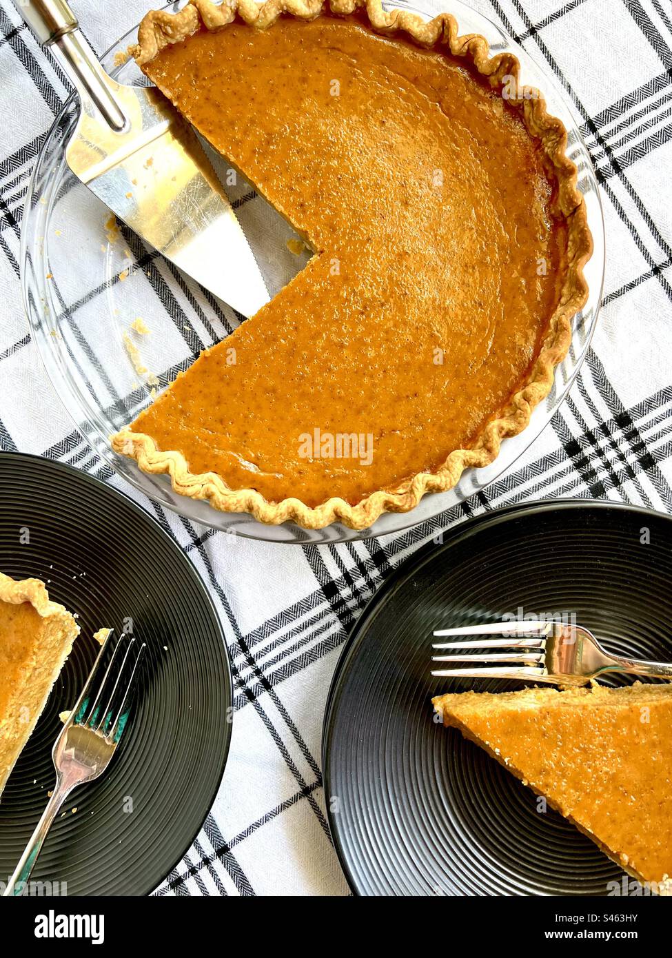Freshly baked pumpkin pie on black plates seen from above Stock Photo
