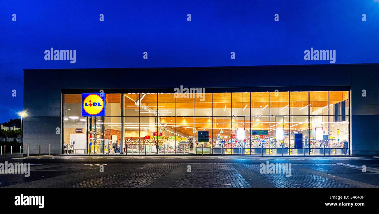 A Lidl supermarket store in Belgard, Dublin, Ireland, illuminated by the stores bright lights. - Smartphone Captured Stock Image