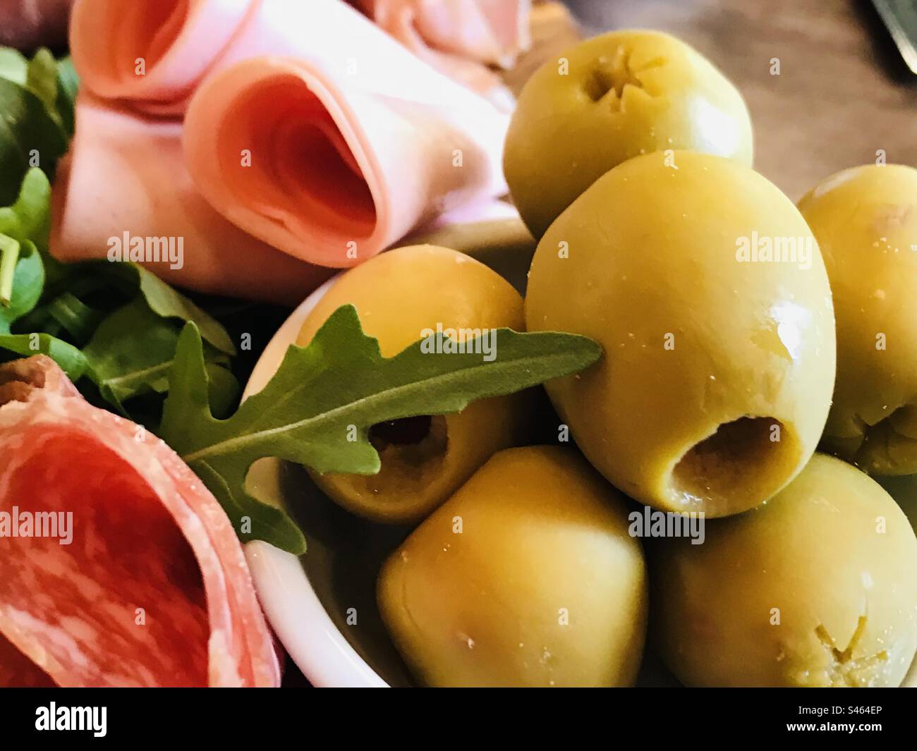 Green Olives on a deli platter with meats at the side Stock Photo Alamy