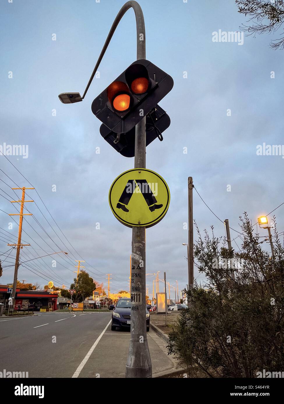 Road signal and traffic sign indicating pedestrian crossing against sky and road. - Smartphone Captured Stock Image