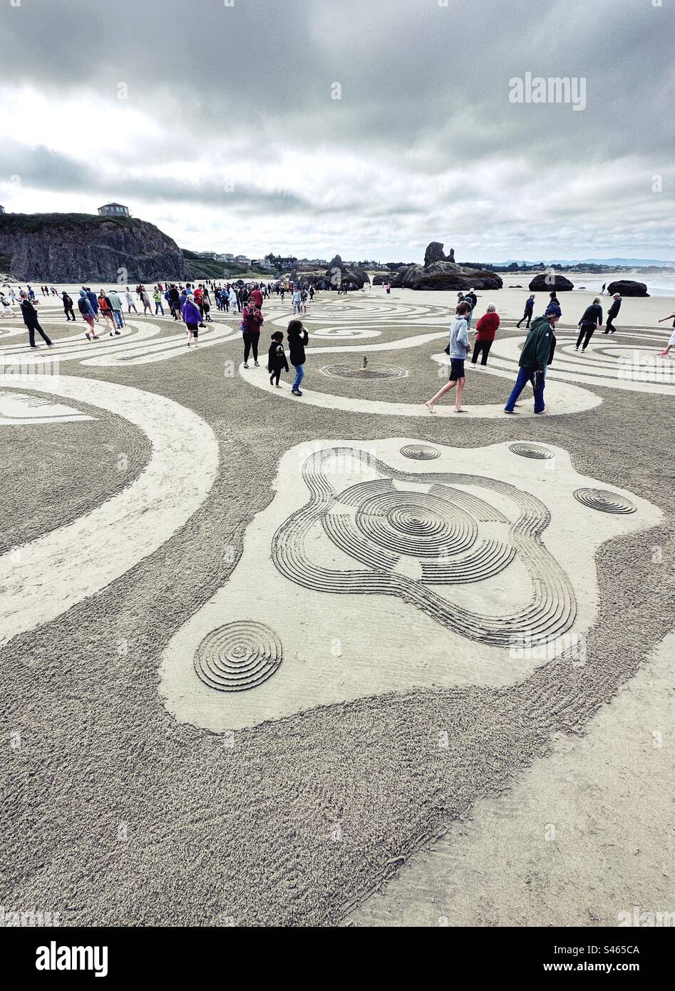 People walking a sand labyrinth at Face Rock beach in Bandon, Oregon. Stock Photo