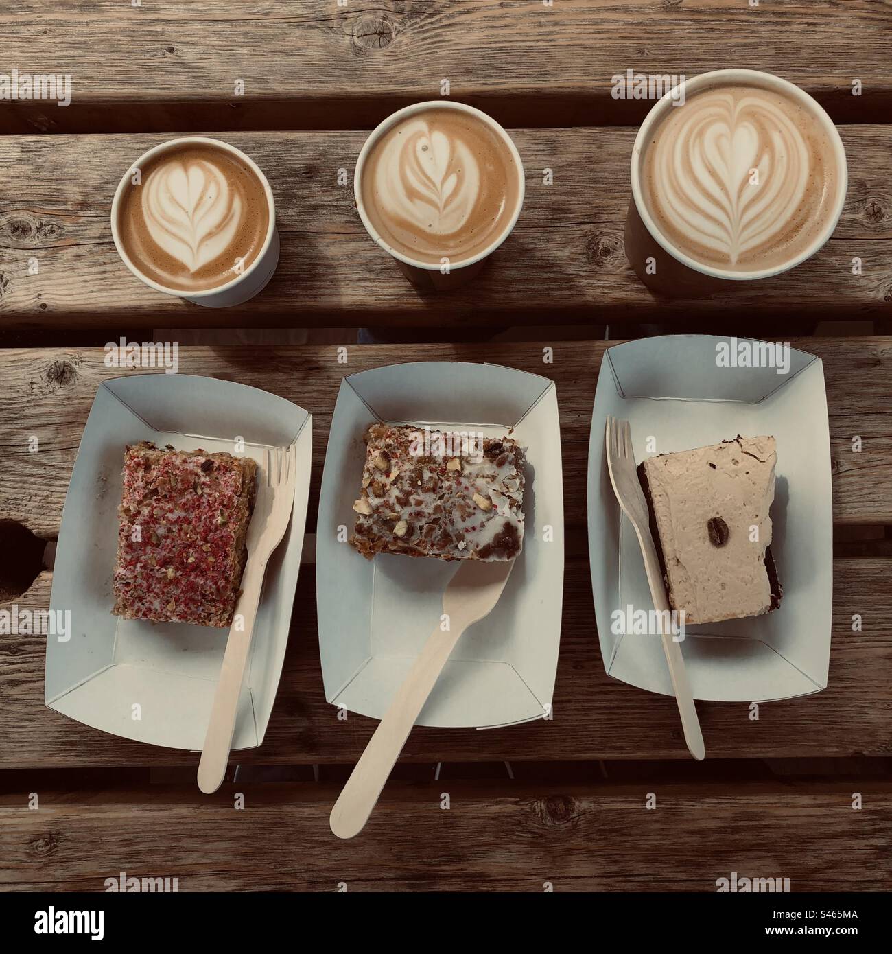 Cortado, flat white and cappuccino with 3 pieces of cake on Holy Island UK at Pilgrim’s Coffee Stock Photo