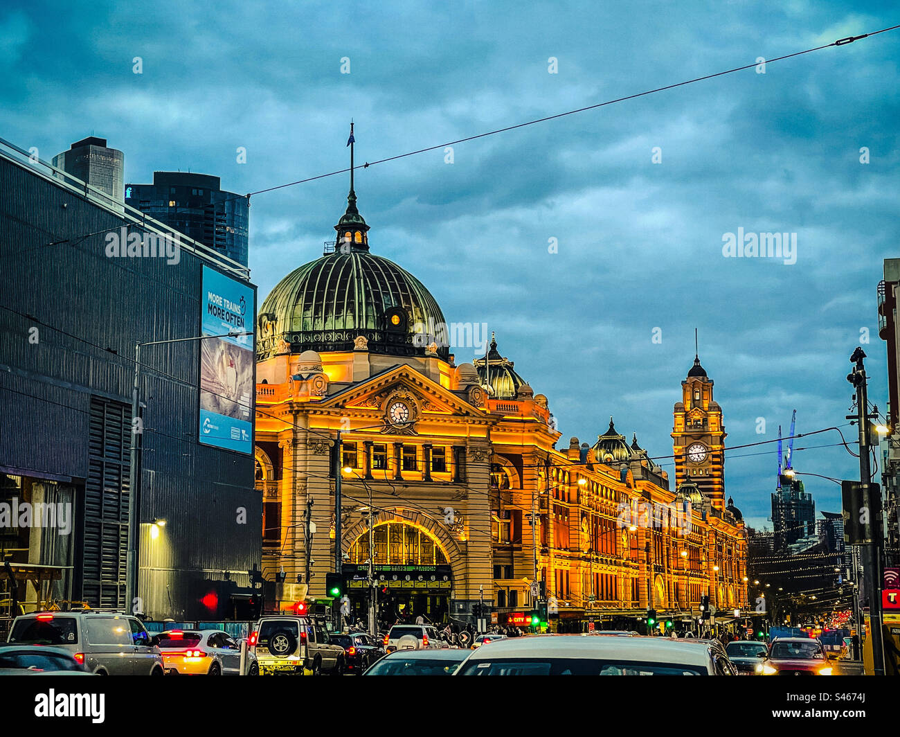 Flinders Street Railway Station, city buildings and congested road in Melbourne CBD, Victoria, Australia against cloudy blue sky at sunset in winter. - Smartphone Captured Stock Image