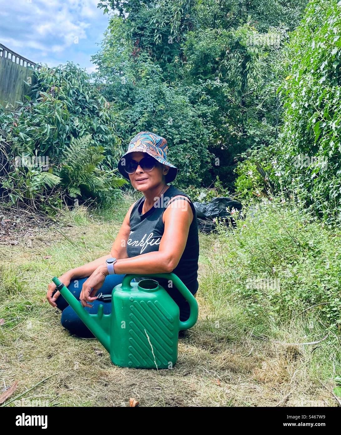 A young woman takes a rest from gardening. - Smartphone Captured Stock Image