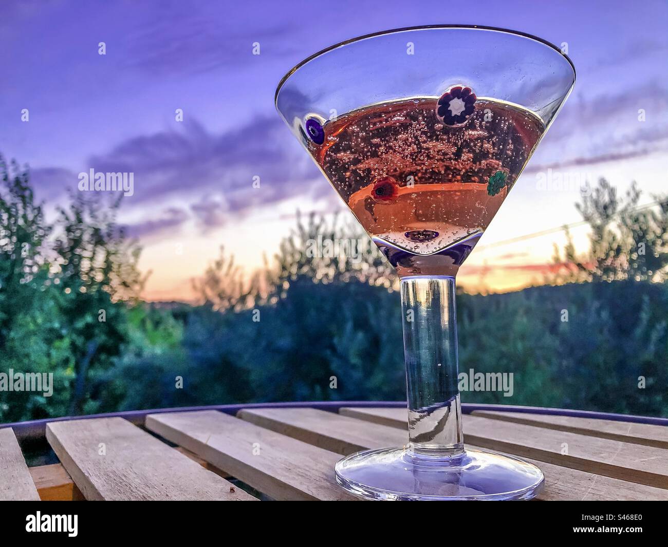 A glass of pink fizz against a purple sunset - Smartphone Captured Stock Image