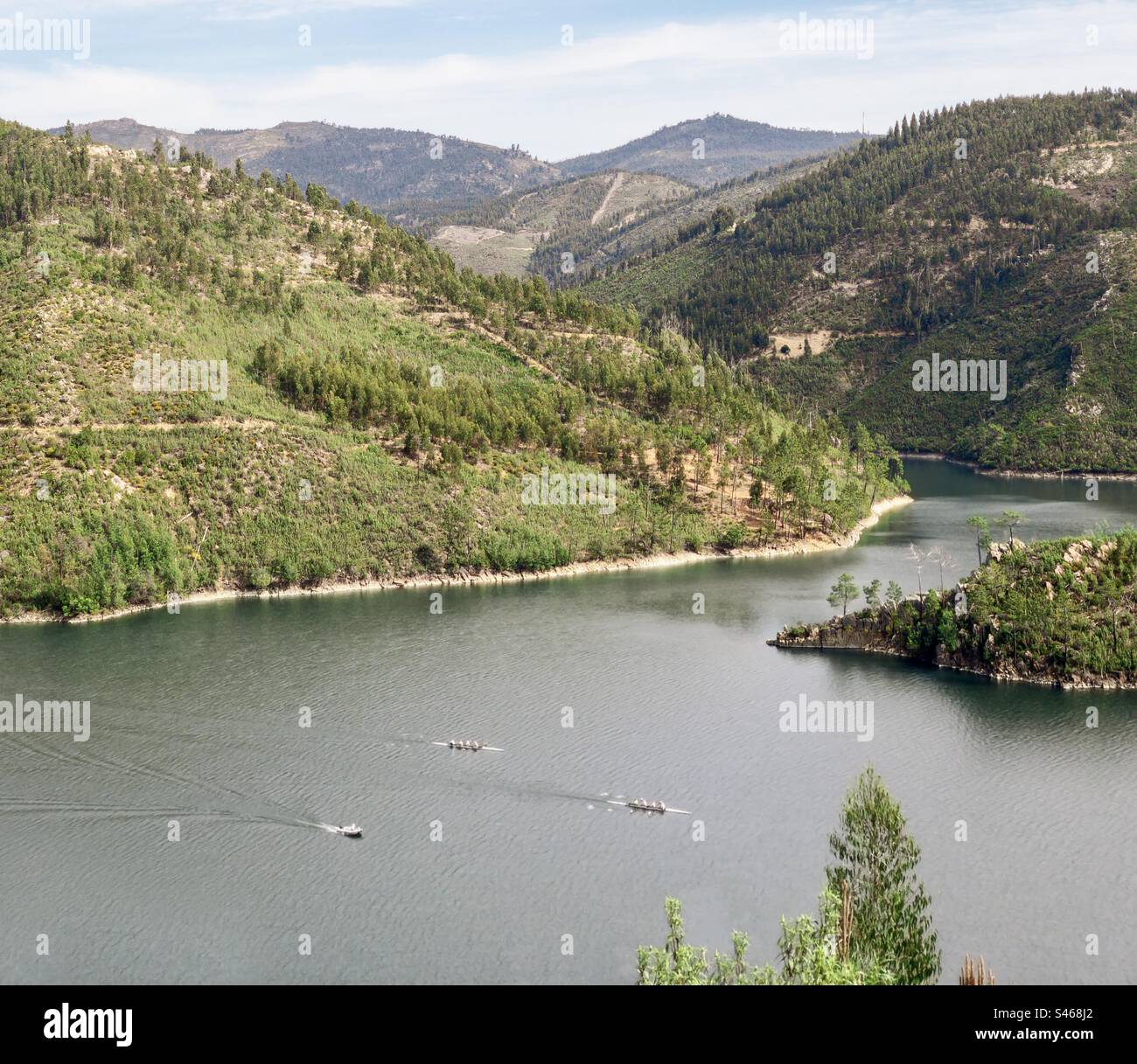 Tiny rowers on the river Zêzere, surrounded by mountainous landscape - Smartphone Captured Stock Image