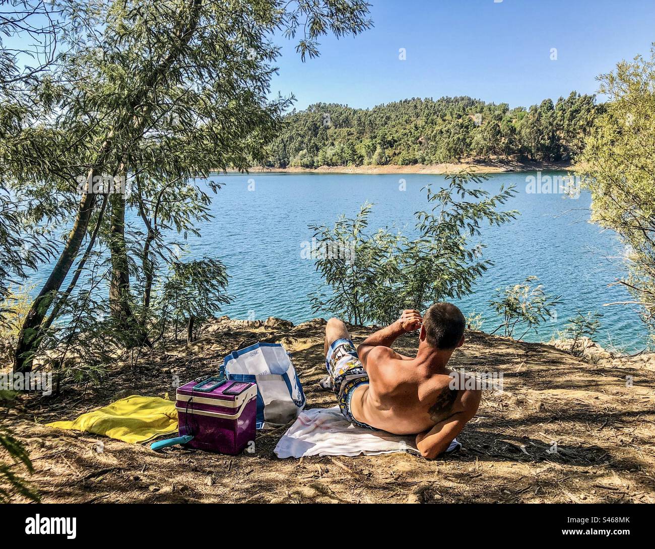 A man enjoys a summer’s day by the river in Central Portugal - Smartphone Captured Stock Image