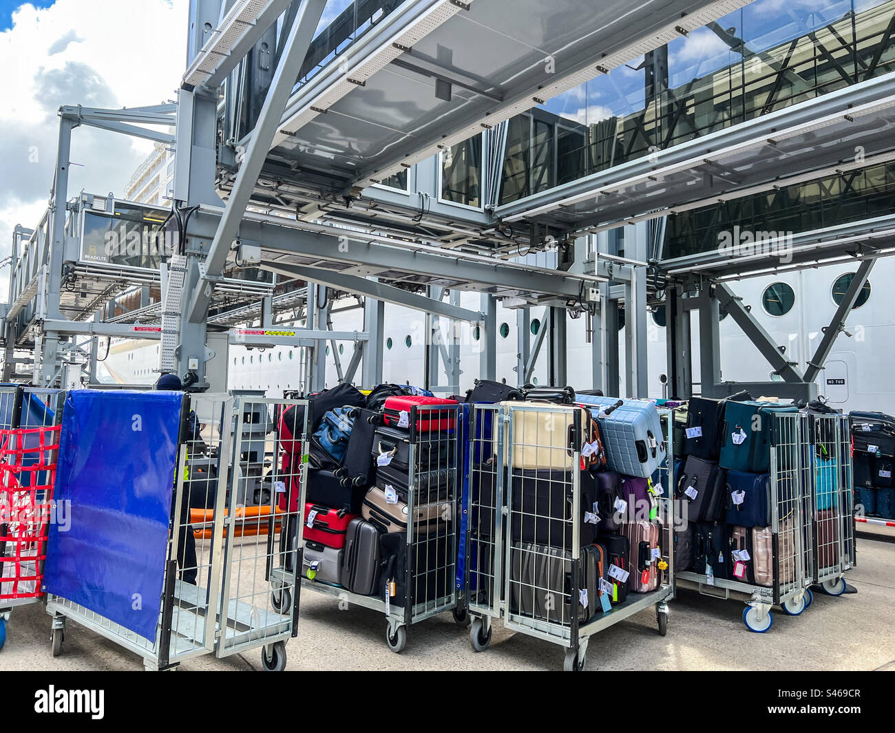 Containers loaded with luggage and suitcases boarding a large cruise ship Stock Photo