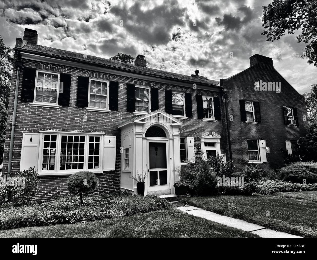 Old, brick building in historic district of downtown, Worcester, Massachusetts, USA. Family, two-story house.  Black and white filter. - Smartphone Captured Stock Image