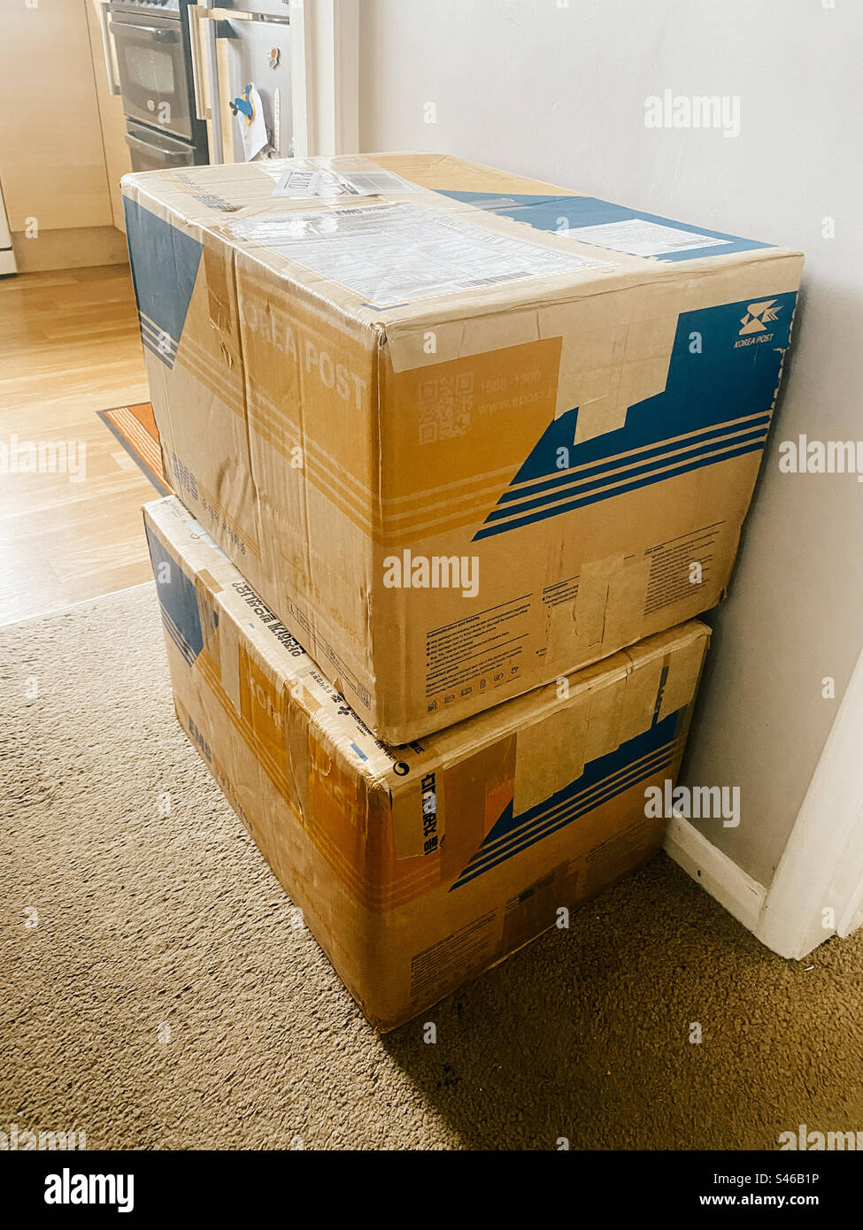 Large boxes, packages received from a courier stacked against a wall. - Smartphone Captured Stock Image