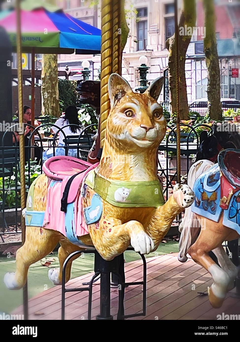 New York City Briant Park carousel riding cat, 2023, USA - Smartphone Captured Stock Image