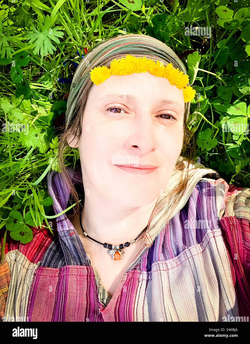 Hippie chick lays in the long grass - Smartphone Captured Stock Image