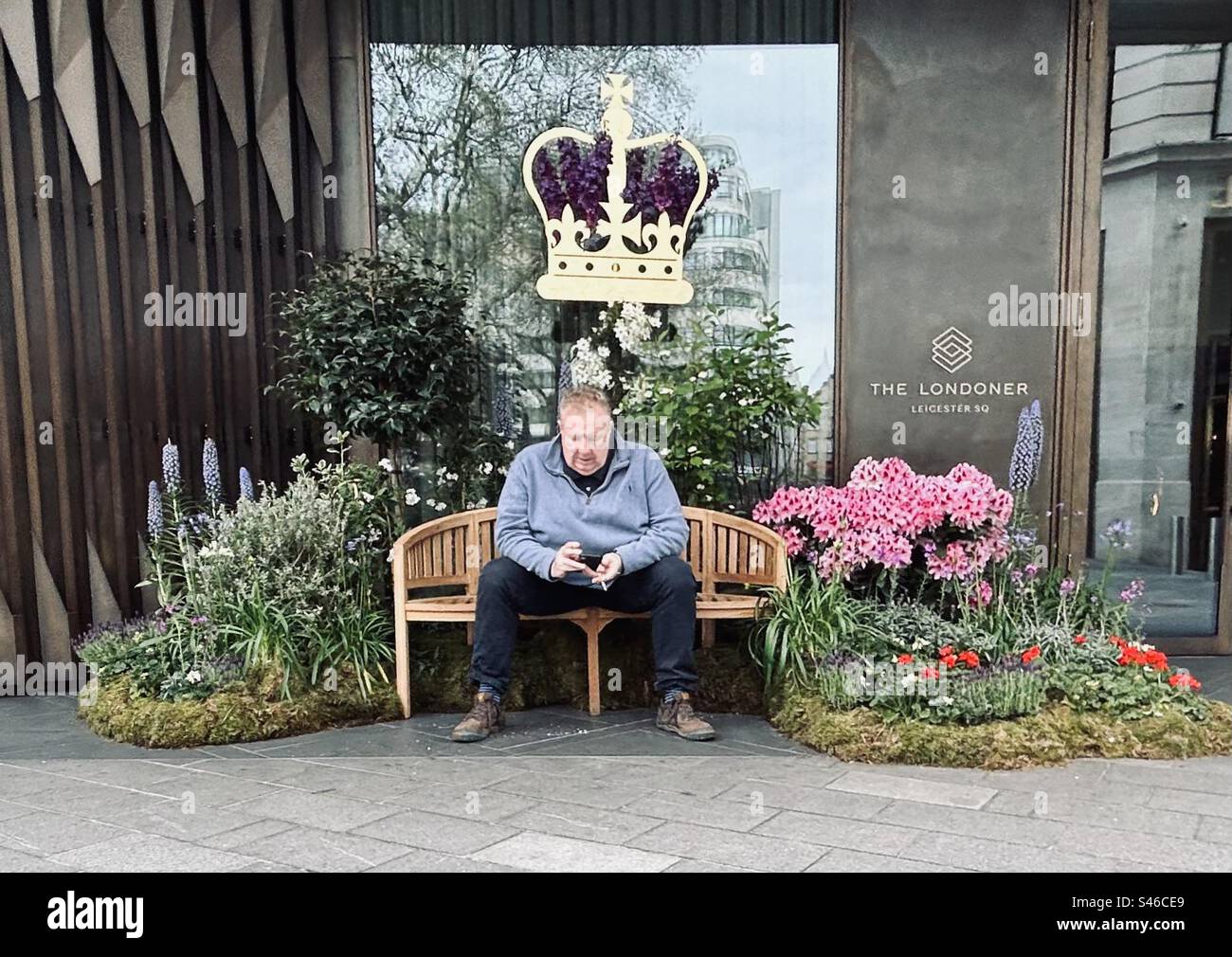 Man sitting under a crown around the time of King Charles’ coronation Stock Photo