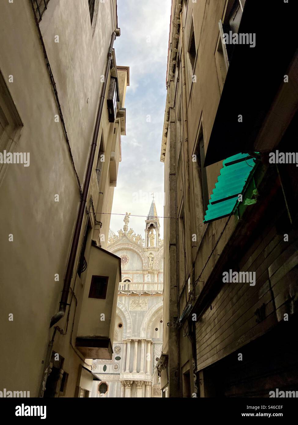 St. Mark’s Basilica dominates the background at the end of a narrow street in Venice - Smartphone Captured Stock Image