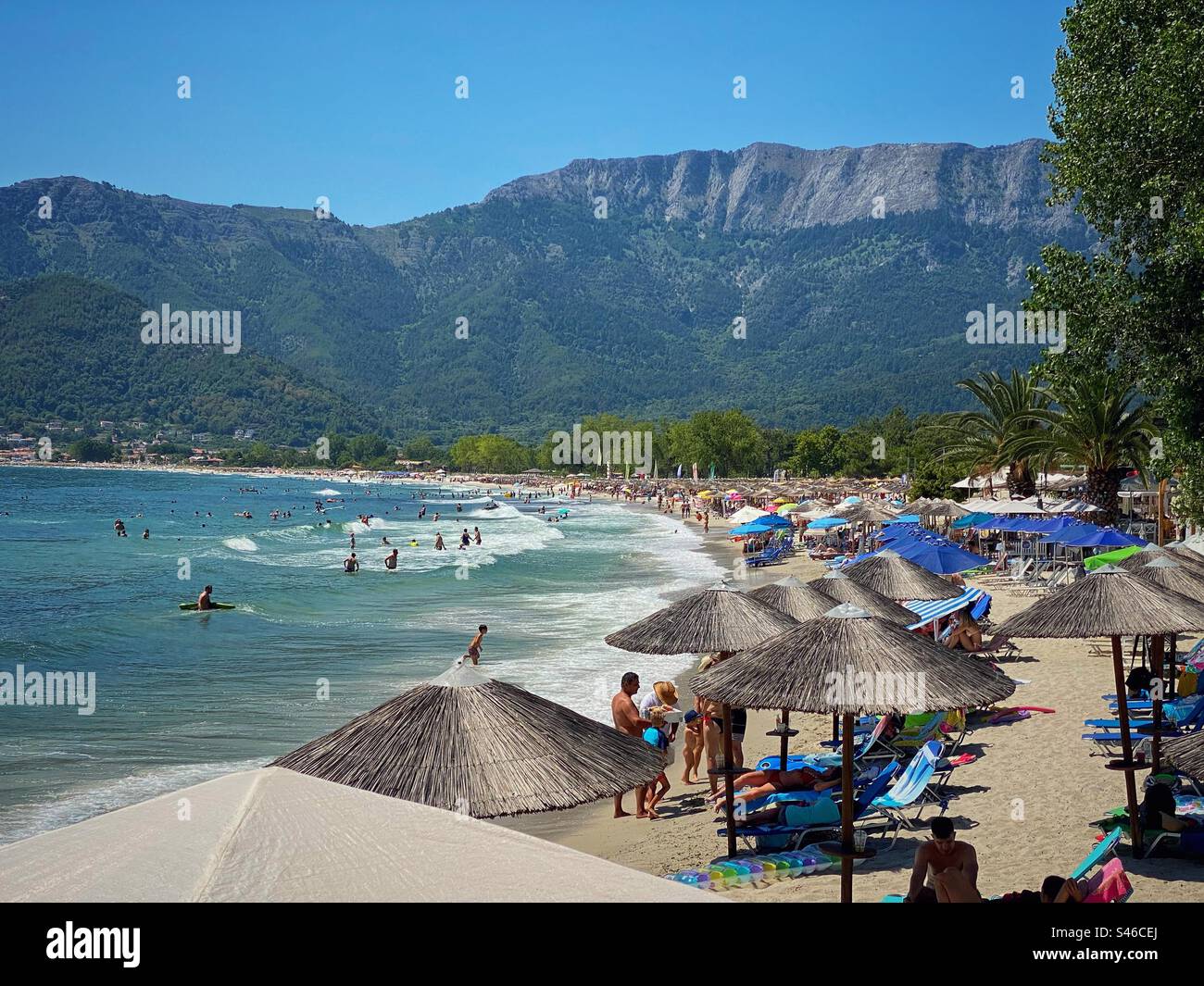 Sea view with sun umbrellas and mountains on Golden Beach on Thassos island, Greece. - Smartphone Captured Stock Image