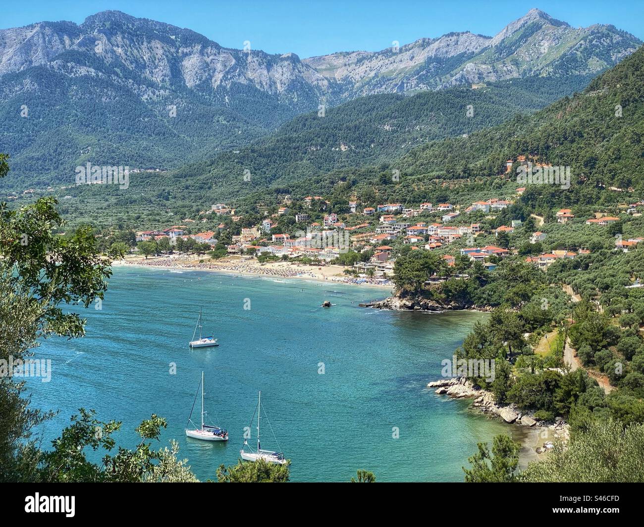 Scenic high-angle view at Golden Beach with sea, boats, mountains, town and forests on Thassos island, Greece. - Smartphone Captured Stock Image