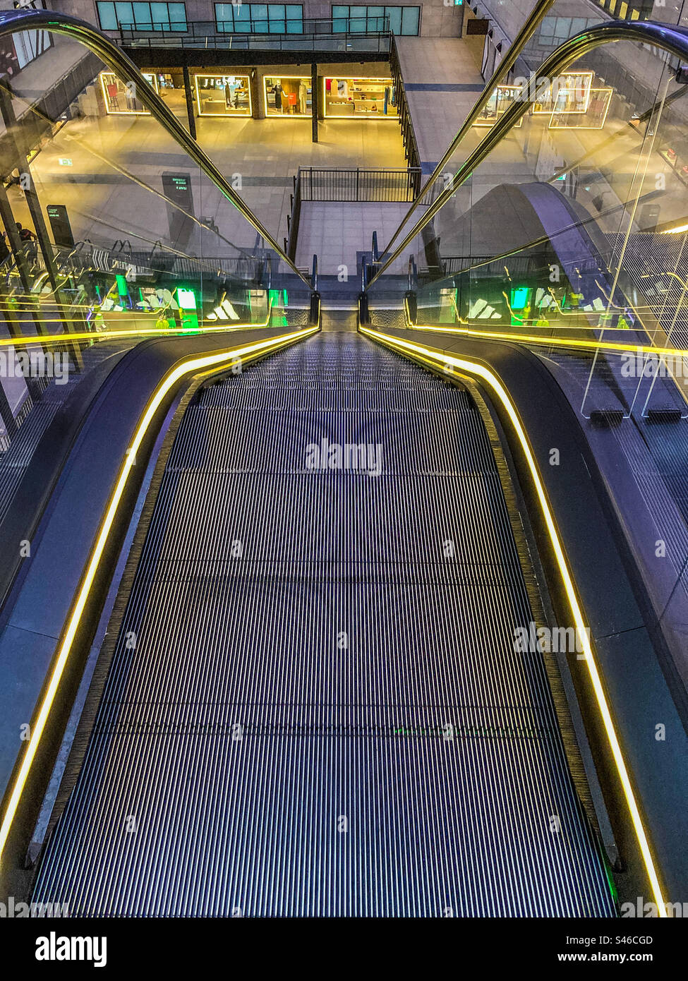 Looking down an illuminated escalator in the new Battersea Power Station Commercial Complex - Smartphone Captured Stock Image