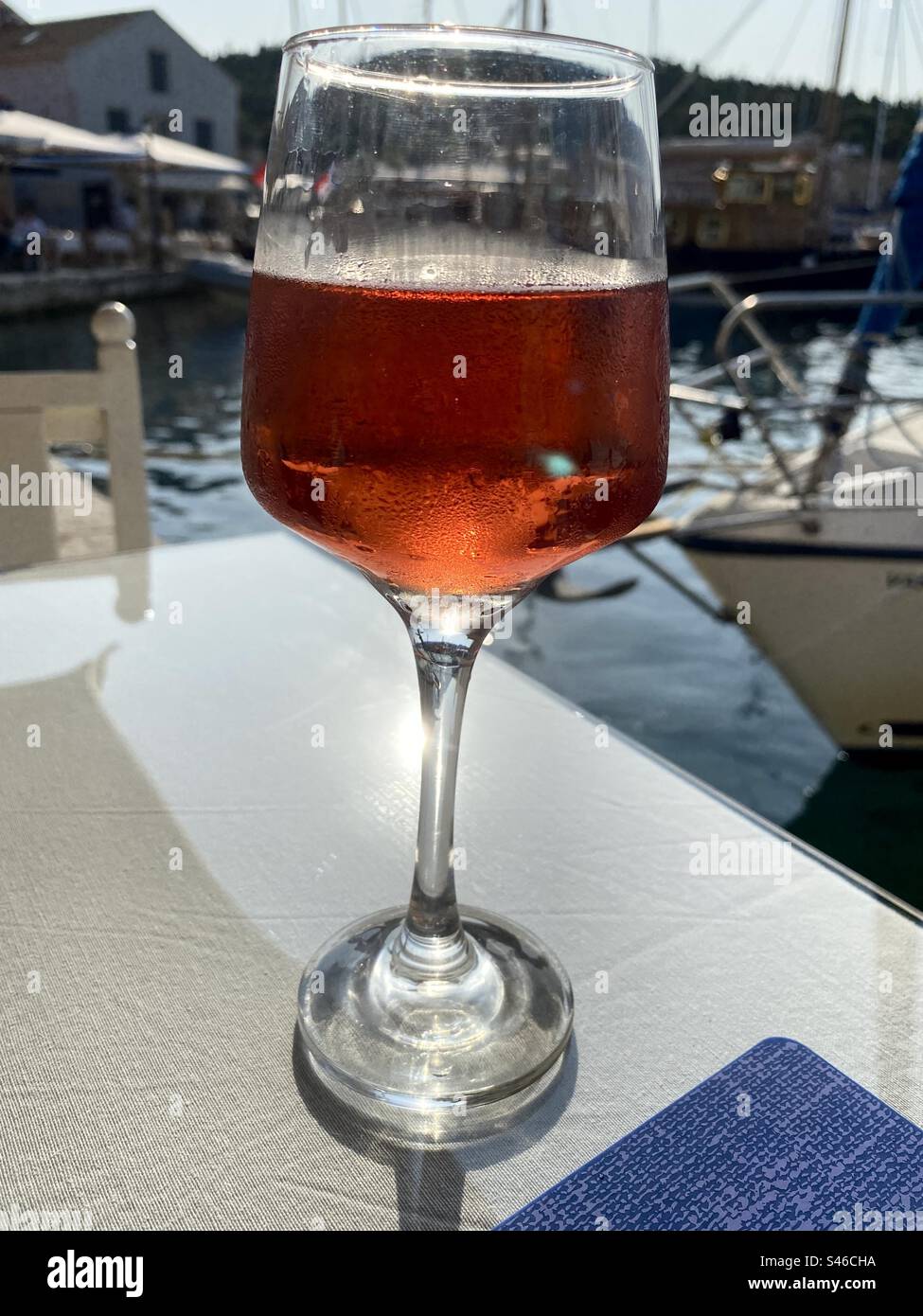 A glass of rose over the harbour, summertime in Kefalonia, Greece - Smartphone Captured Stock Image